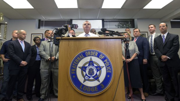 Gene Ryan, centre, president of the Baltimore Fraternal Order of Police, flanked by attorneys and accused police officers, speaks after prosecutors dropped remaining charges against the three officers awaiting trial in Freddie Gray's death.