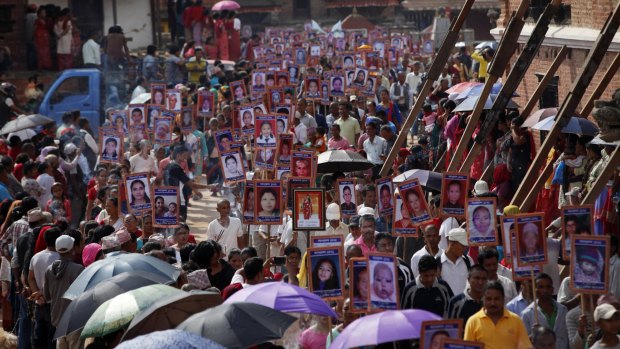 Nepalese people carry portraits of their loved ones who lost their lives in this year's earthquakes  in Bhaktapur, Nepal, on Wednesday.