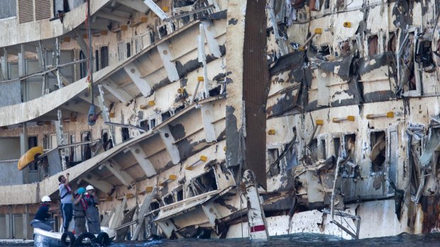 Workers inspect the wreck of the Costa Concordia after it was righted in September 2013.