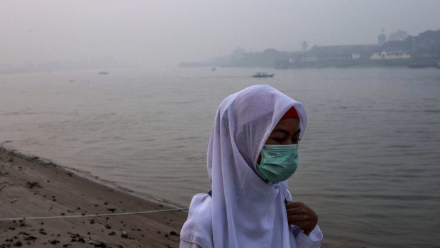 A student wears a face mask as she walks to school in Palembang, South Sumatra, Indonesia.