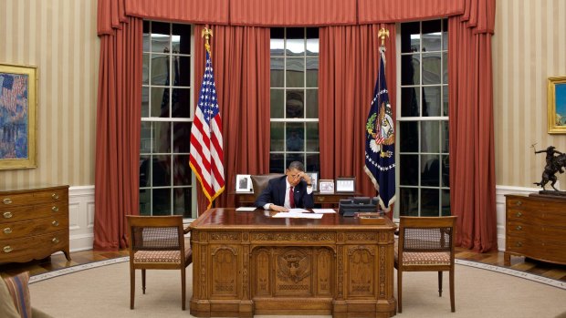 President Barack Obama sits in a relatively  austere oval office. 