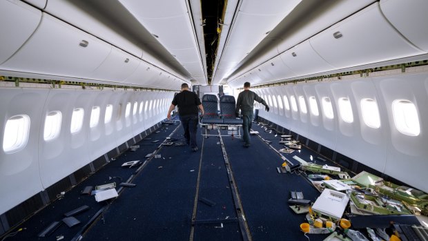 Engineers carry out passenger seats as they work on the conversion of a Boeing 767 passenger plane to a cargo plane at the Israel Aerospace Industries.
