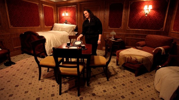 A woman positions a plate in a recreation of a first class cabin on the Titanic in an exhibition of artefacts recovered from the wreck in London, in 2010.