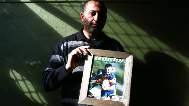 Grieving father: Azzam Hrouk with a picture of his son Mahmoud.