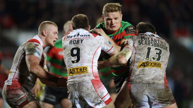 Pommy granite: George Burgess runs into a wall of St Helens defenders.