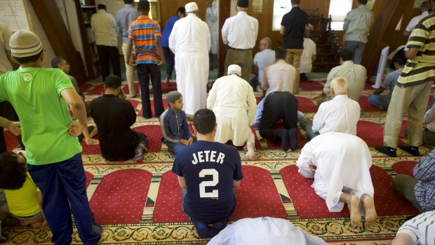 Haaris Siddiq, centre, wears the shirt number of baseball star Derek Jeter during prayer in Yardley, Pennsylvania.  