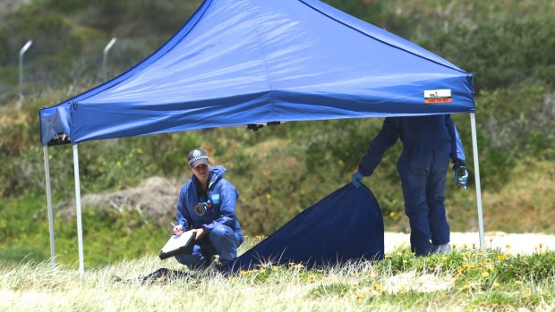 Police examine the beach where the baby was found in November, 2014.