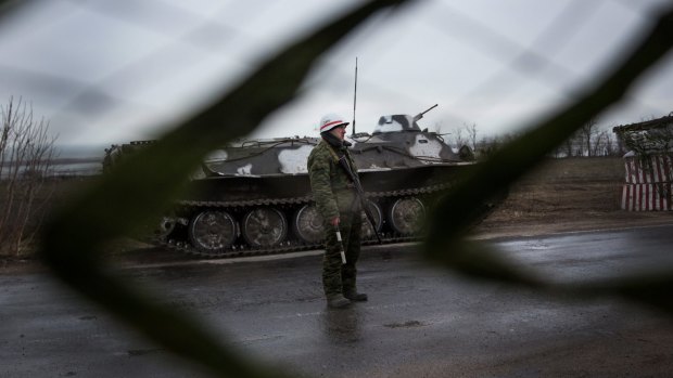 A pro-Russian rebel guards a checkpoint into the eastern Ukraine town of Novoazovsk.