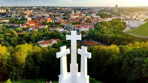 Aerial view of the Three Crosses monument overlooking Vilnius Old Town on sunset. 