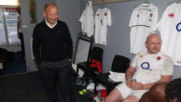 The spoils of victory: England coach Eddie Jones looks on as Dan Cole celebrates with teammates after their victory in the Test match against the Wallabies at Allianz Stadium.