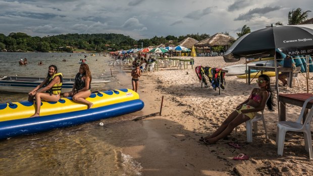 Beachgoers relax and enjoy the amenities along the Tapajos River in Alter Do Chao.