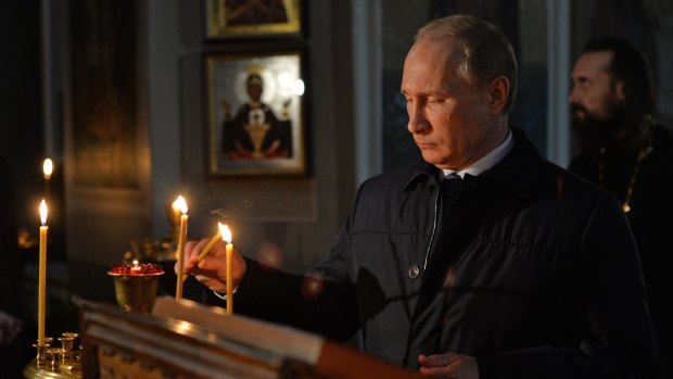 Russian President Vladimir Putin lights a candle while visiting the Lermontov museum in the village of Lermontovo near Penza.