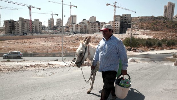 A Palestinian man walks near the construction site of a new housing unit in the East Jerusalem settlement of Har Homa, deemed illegal by the international community.