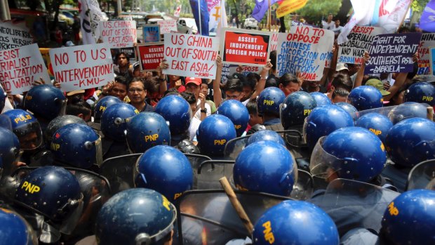 Riot police prevent protesters opposed to US and Chinese militarisation of the region from approaching the venue of the leaders' summit.