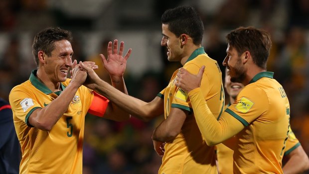 Easy night: Mark Milligan congratulates Socceroos teammate Tom Rogic after he scored one of his two goals in the 5-0 victory against Bangladesh.