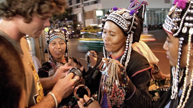 A tourist bargains with a group at a street market in Bangkok, Thailand.