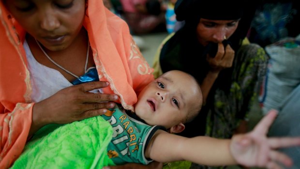 Rohingya woman Rahima, left, sits with her six-month-old child Jewel at a temporary shelter after being detained by Bangladeshi border guards while crossing the Naf River to enter Bangladesh.