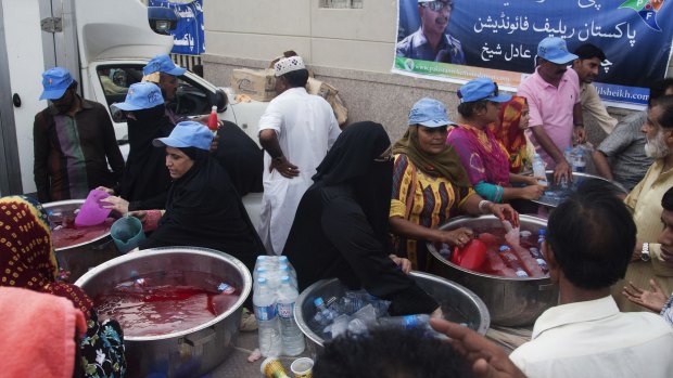 Pakistani volunteers provide cold drinks to people suffering from the hot weather in Karachi on Wednesday.