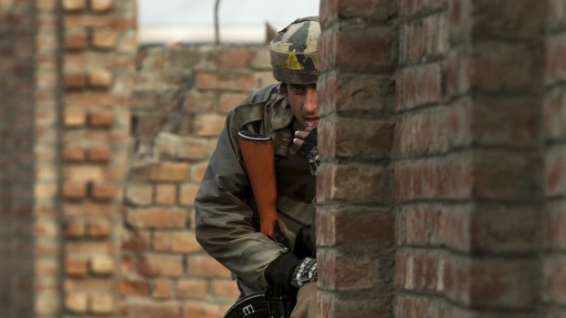 An Indian Army soldier takes his position during a battle between Indian security forces and Kashmiri rebels in Pampore, near Srinagar, on Monday.