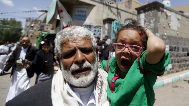 An injured girl is carried out of a mosque that was attacked by a suicide bomber in Sanaa.