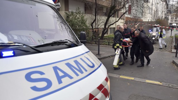 A victim is evacuated on a stretcher after armed gunmen stormed the offices of the French satirical magazine Charlie Hebdo in Paris.