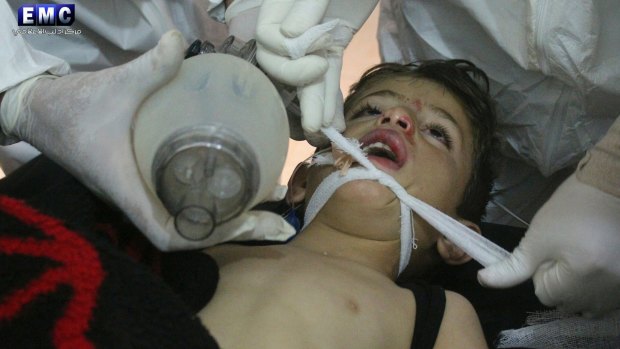 This photo provided by the Edlib Media Center, which has been authenticated, shows Syrian doctors treating a child following a suspected chemical attack.