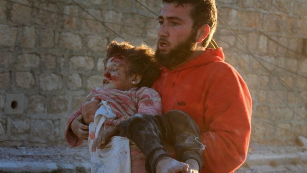 A child is seen after she was pulled from the wreckage of a building in the Aleppo region.