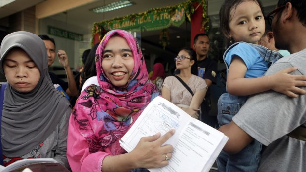 Wulansari shows her child's vaccine record book at Harapan Bunda hospital in Jakarta.