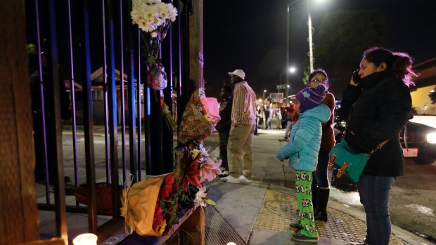 Flowers and candles are placed at the site of the California warehouse fire on Saturday.