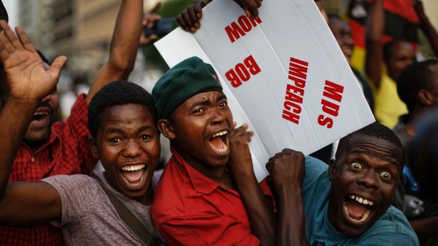 Zimbabweans celebrate Robert Mugabe outside Parliament on Tuesday.