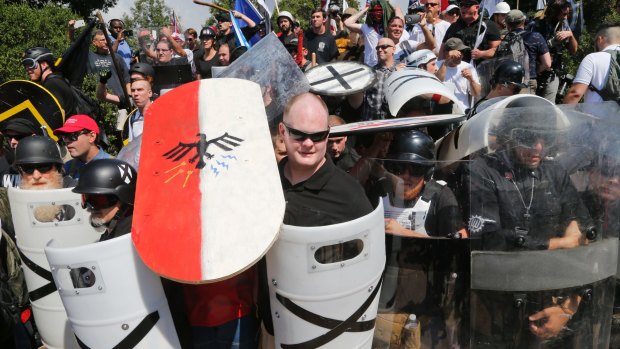White nationalist demonstrators use shields as they guard the entrance to Lee Park in Charlottesville on Saturday.
