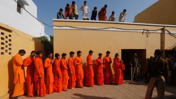 Sadhus, or Hindu holy men, stand in a queue to cast their vote at a polling station in Allahabad, in the northern Indian state of Uttar Pradesh.