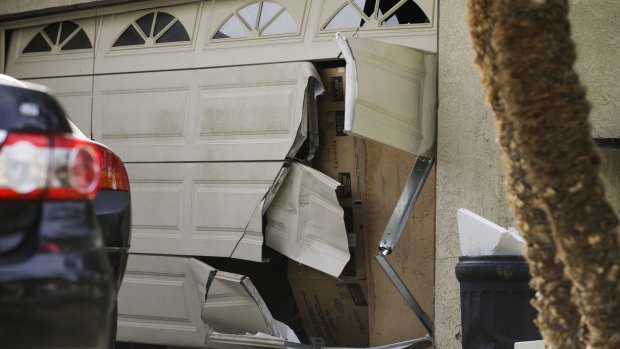 A garage door of Enrique Marquez's home is broken in after an FBI raid, in Riverside, California, in December 2015.