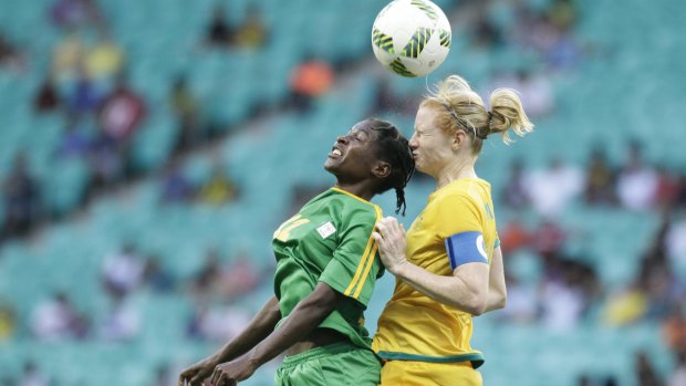 Zimbabwe's Marjory Nyaumwe, left, and Australia's Clare Polkinghorne jump for the ball on Tuesday.