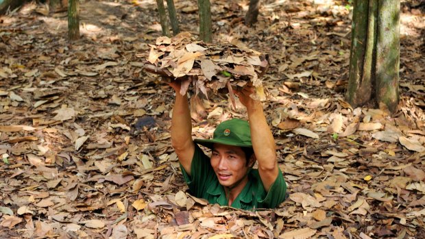 Vietnamese soldier gliding into the entrance of the Viet Cong tunnel system in Cu Chi.