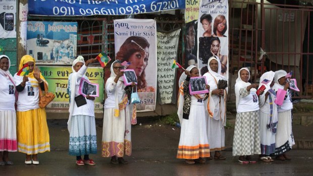 Women wave as US President Barack Obama's motorcade passes just outside Addis Ababa Bole International Airport in Ethiopia on Sunday.