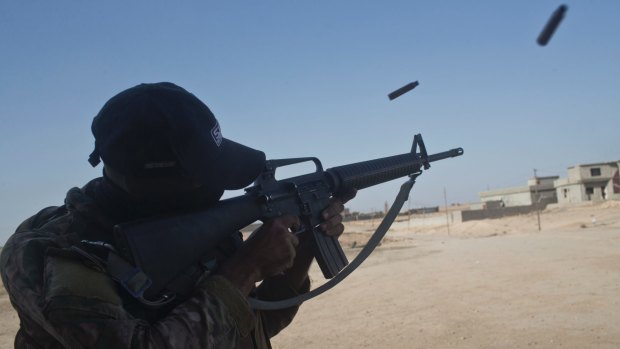 An Iraqi army soldier fires his rifle in the town of Shura on Saturday.