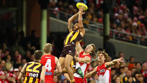 Cyril Rioli soars over a crowd of Swans players to mark.