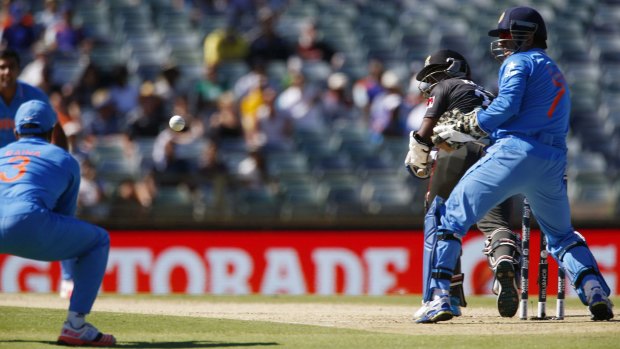 India's Suresh Raina prepares to take a catch at slip to send the UAE's Krishna Karate on his way as M.S. Dhoni watches.