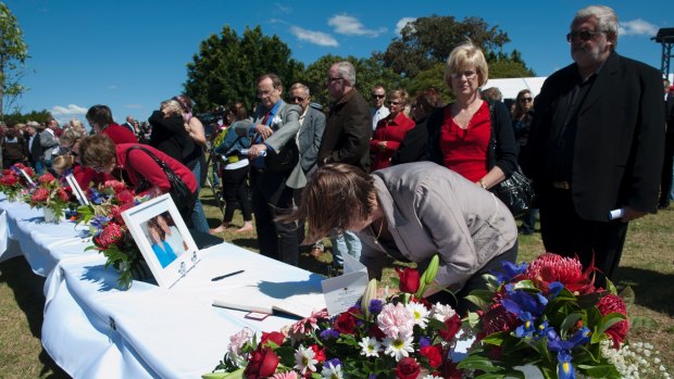 Crowds sign memorial books at a memorial service in Brisbane for six people killed when a vintage plane crashed into a hill in the Sunshine Coast hinterland. 