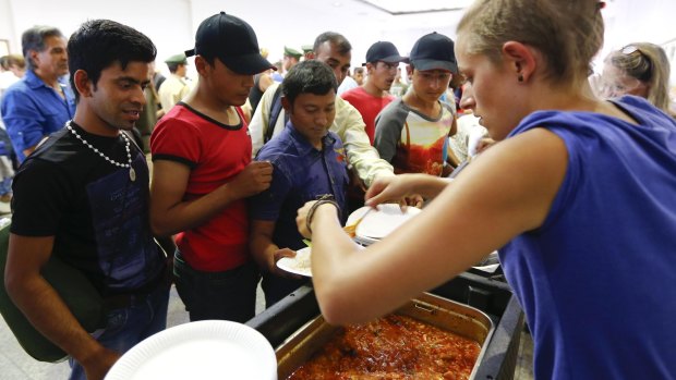 Volunteers distribute food to migrants coming from Budapest at  the train station in Munich, Germany.