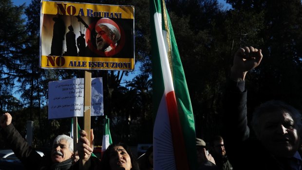 An Iranian opposition supporter holds up a placard bearing a picture of President Hassan Rouhani that reads "No to Rouhani no to executions", during a protest outside the Iranian embassy in Rome.