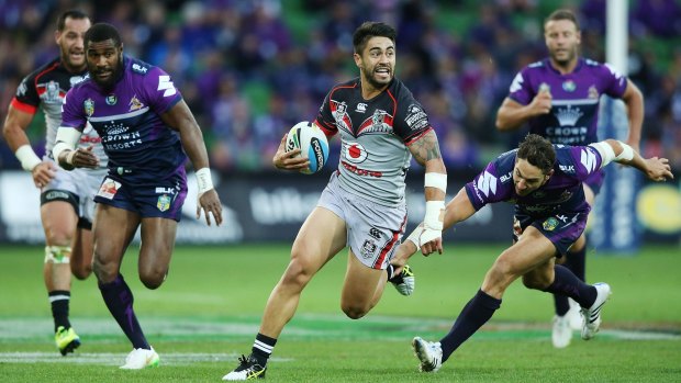 Shaun Johnson of the Warriors is tripped by Billy Slater of the Storm.