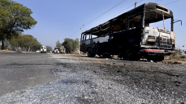 Shattered glass and a gutted bus at the side of the highway between Delhi and Chandigarh at Murthal.