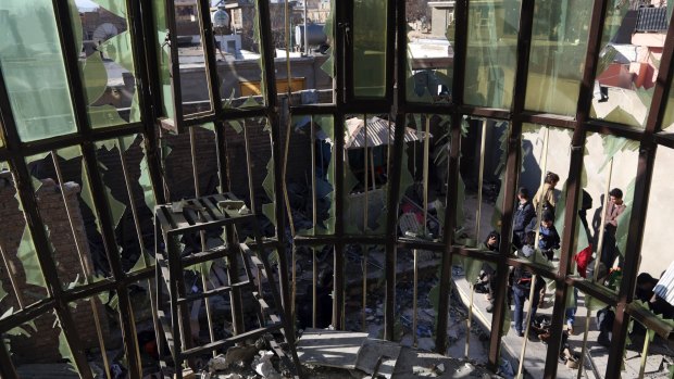 Afghans are seen through a the shattered window of the Shiite cultural centre after a suicide attack in Kabul, Afghanistan.