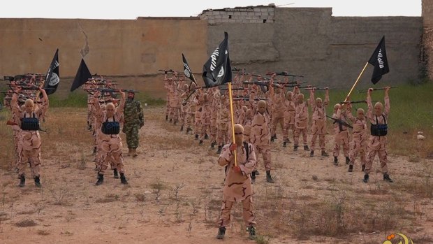 In this photo from a militant website, "lion cubs" hold rifles and Islamic State flags as they exercise at a training camp in Tal Afar, near Mosul in northern Iraq. 