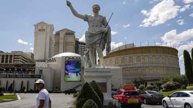 A statue in front of Caesars Palace wears a face mask.