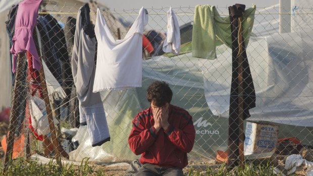 A migrant prays near the Macedonian border in Idomeni, Greece, on Saturday.