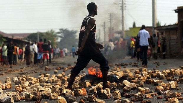  A man walks past a burning tyre during protests against the governing party in Bujumbura in June.