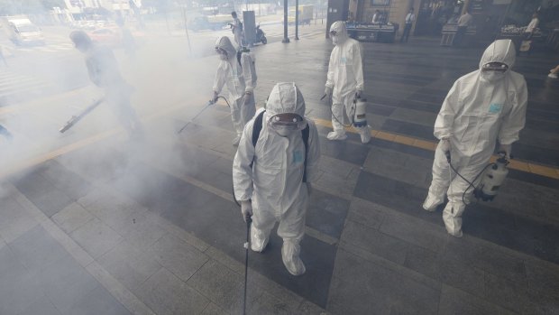 Antiseptic solution is sprayed in an attempt to halt the spread of MERS outside Wangsimni subway station in Seoul on Thursday.
